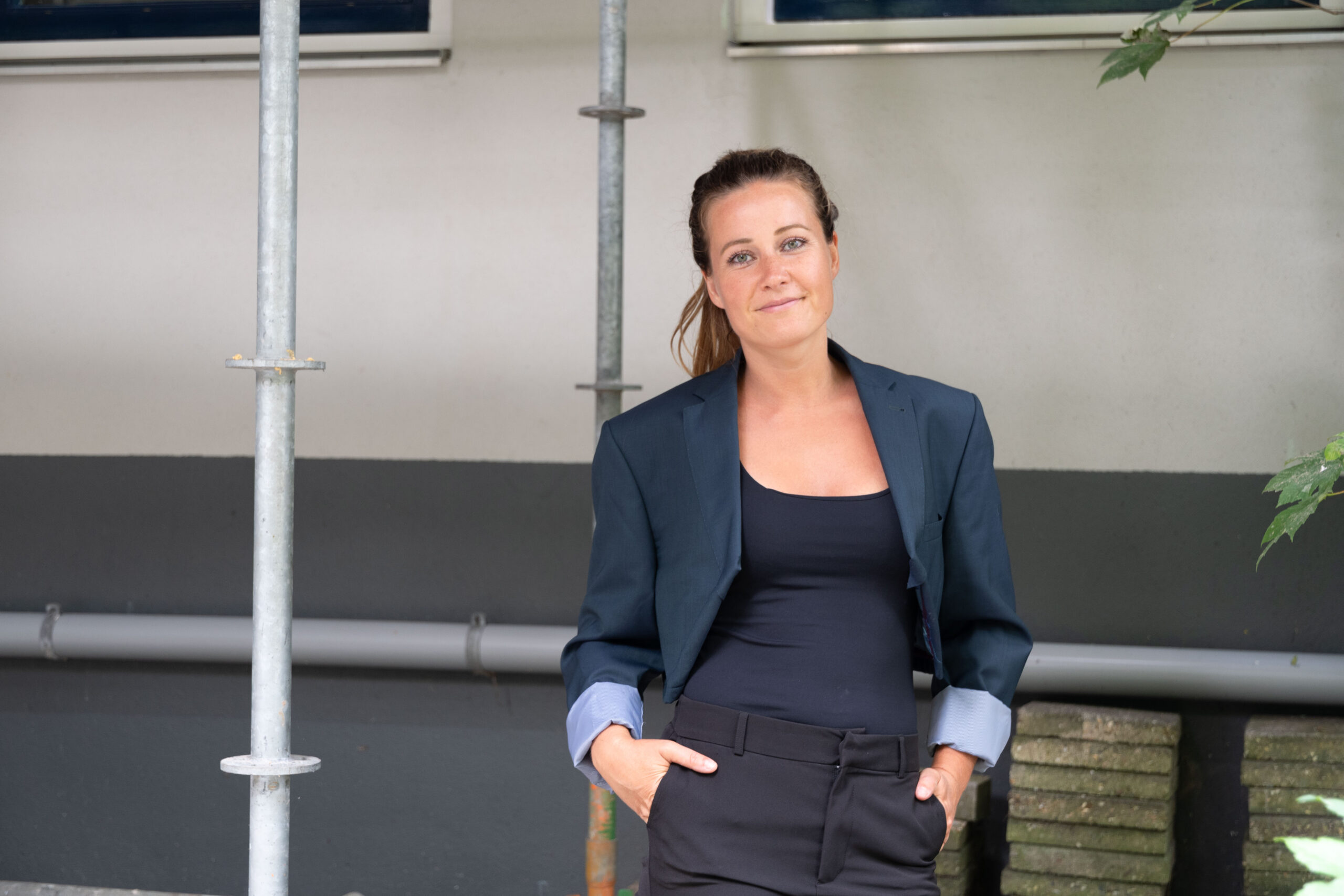 Model met een jasje van Rebel Remake in een industriële omgeving.